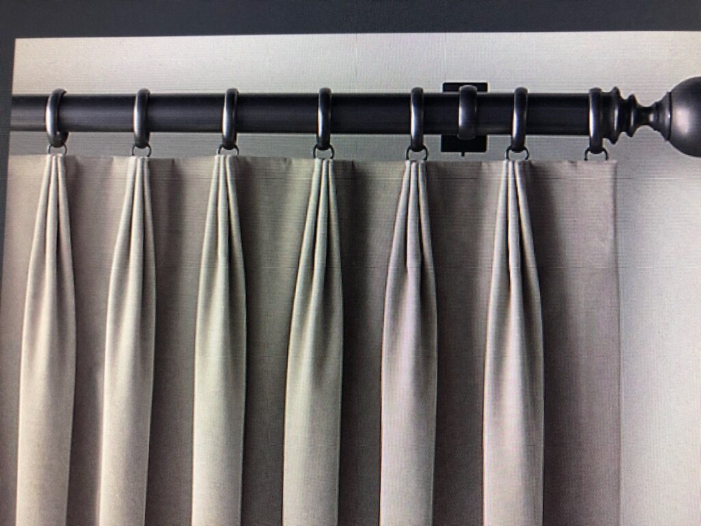 Pinch-pleat drapery style installed on a decorative rod and rings